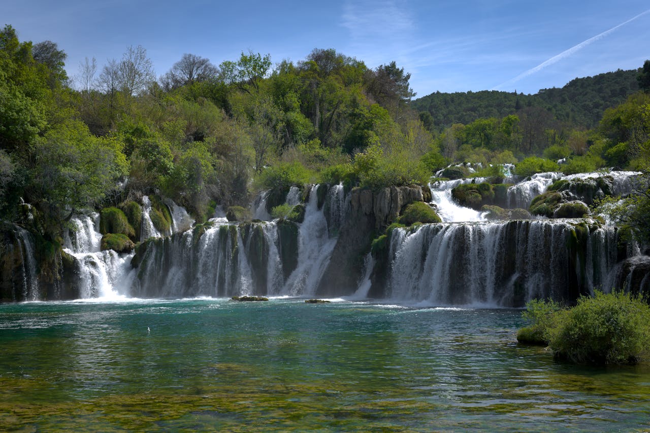Beautiful view of Krka Waterfalls in Šibenik-Knin, Croatia. Lush greenery and cascading water create a serene landscape.